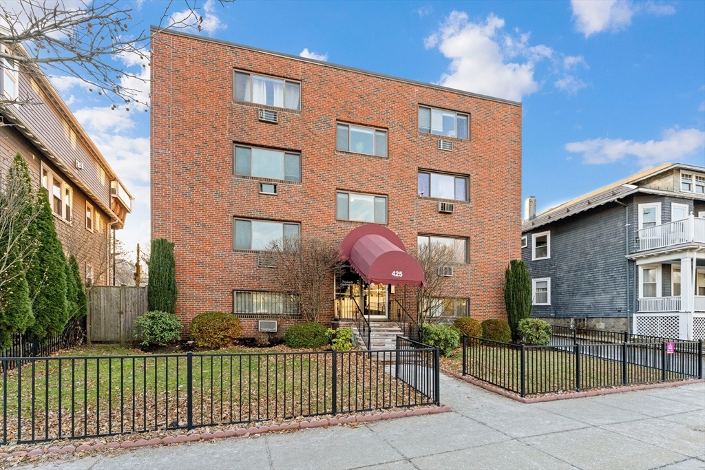 425 South Huntington Avenue, Unit 6 Boston, MA 02130 - Photo 16 of 19 front view of a brick house with a small yard