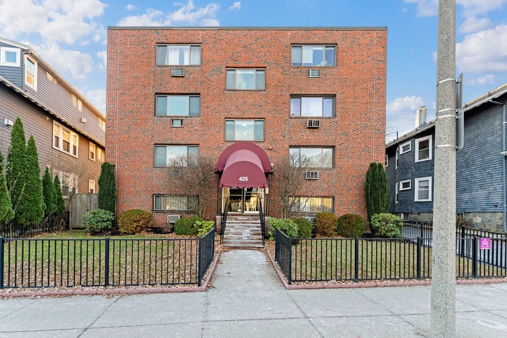 425 South Huntington Avenue, Unit 6 Boston, MA 02130 - Photo 17 of 19 a front view of a brick house with a garden