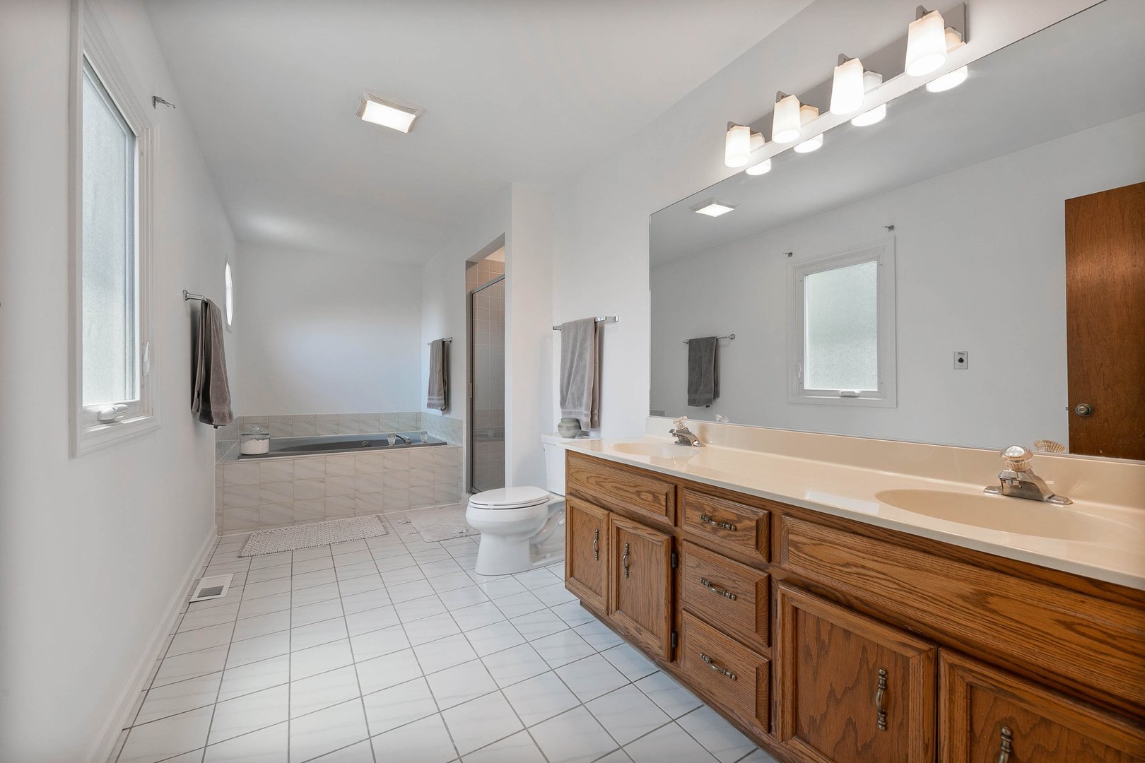 16 Redstart Road Naperville, IL 60565 - Photo 22 of 23 a spacious bathroom with a double vanity sink a toilet a mirror and shower