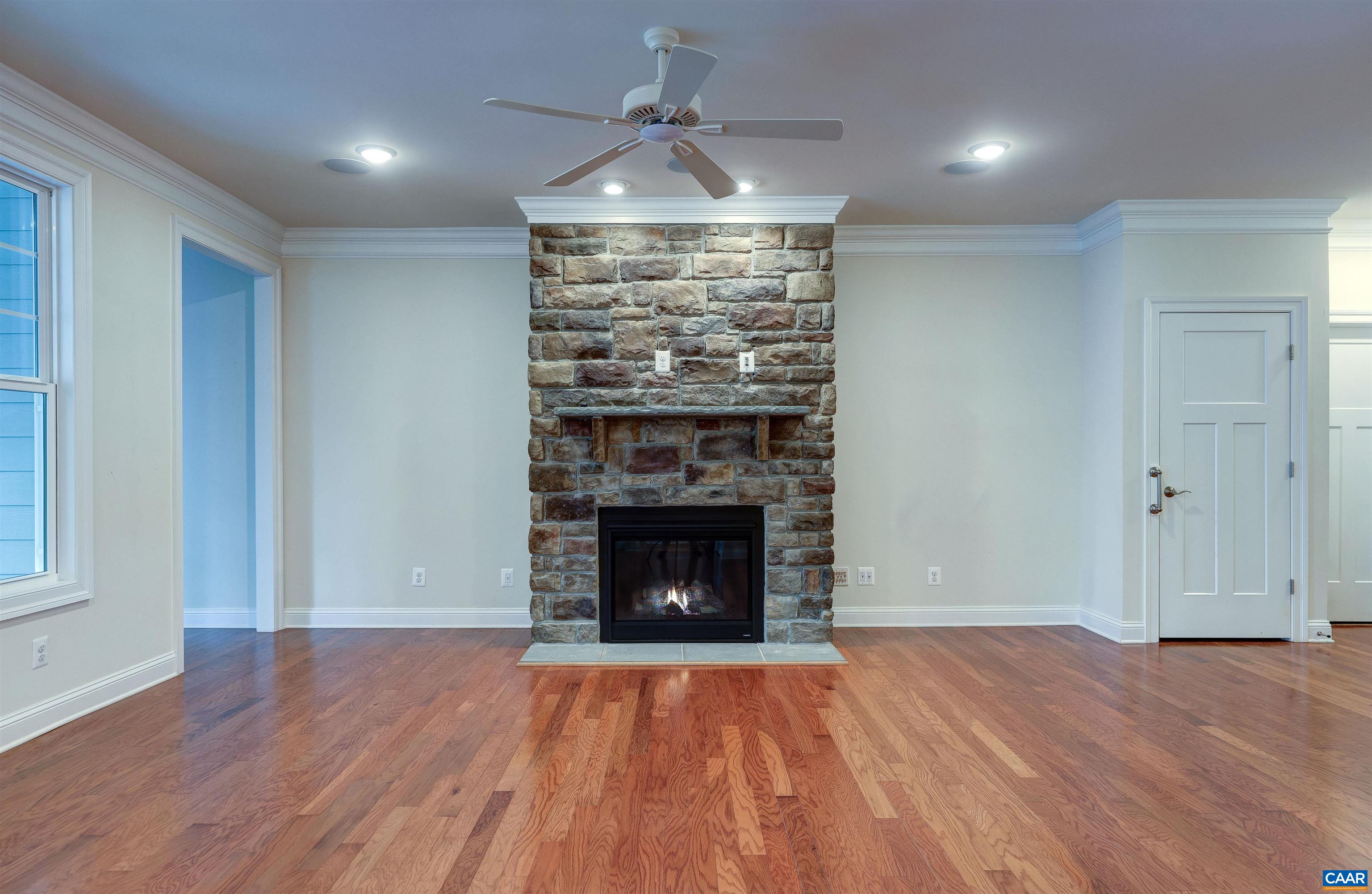 289 Appalachian Lane Zion Crossroads, VA 22942 - Photo 13 of 50 an empty room with wooden floor fireplace and windows