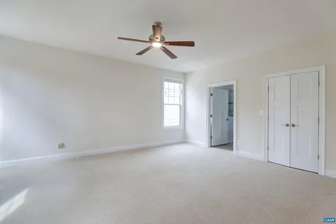 an empty room with wooden floor fireplace and windows