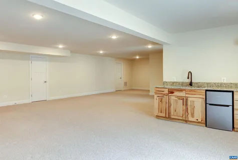 a view of empty room with kitchen