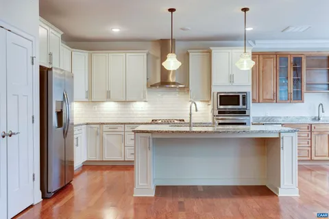 a kitchen with granite countertop a sink stainless steel appliances and cabinets