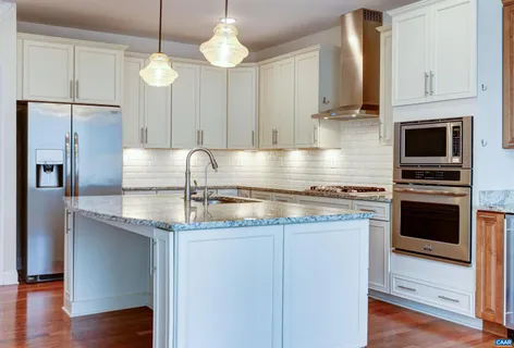 an empty room with wooden floor fireplace and windows