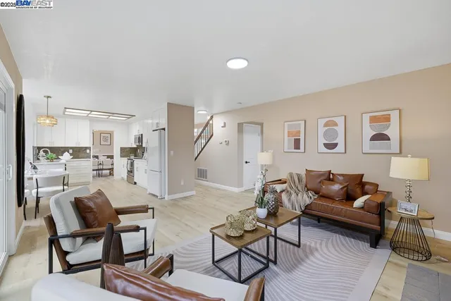 a living room with furniture and kitchen view