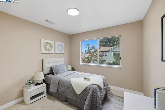 a bedroom with a bed and a painting on the wall