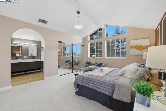 a bedroom with a large bed and a potted plant