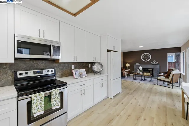 a kitchen with stainless steel appliances a stove a microwave a sink and cabinets
