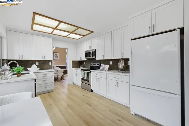 a kitchen with white cabinets and stainless steel appliances