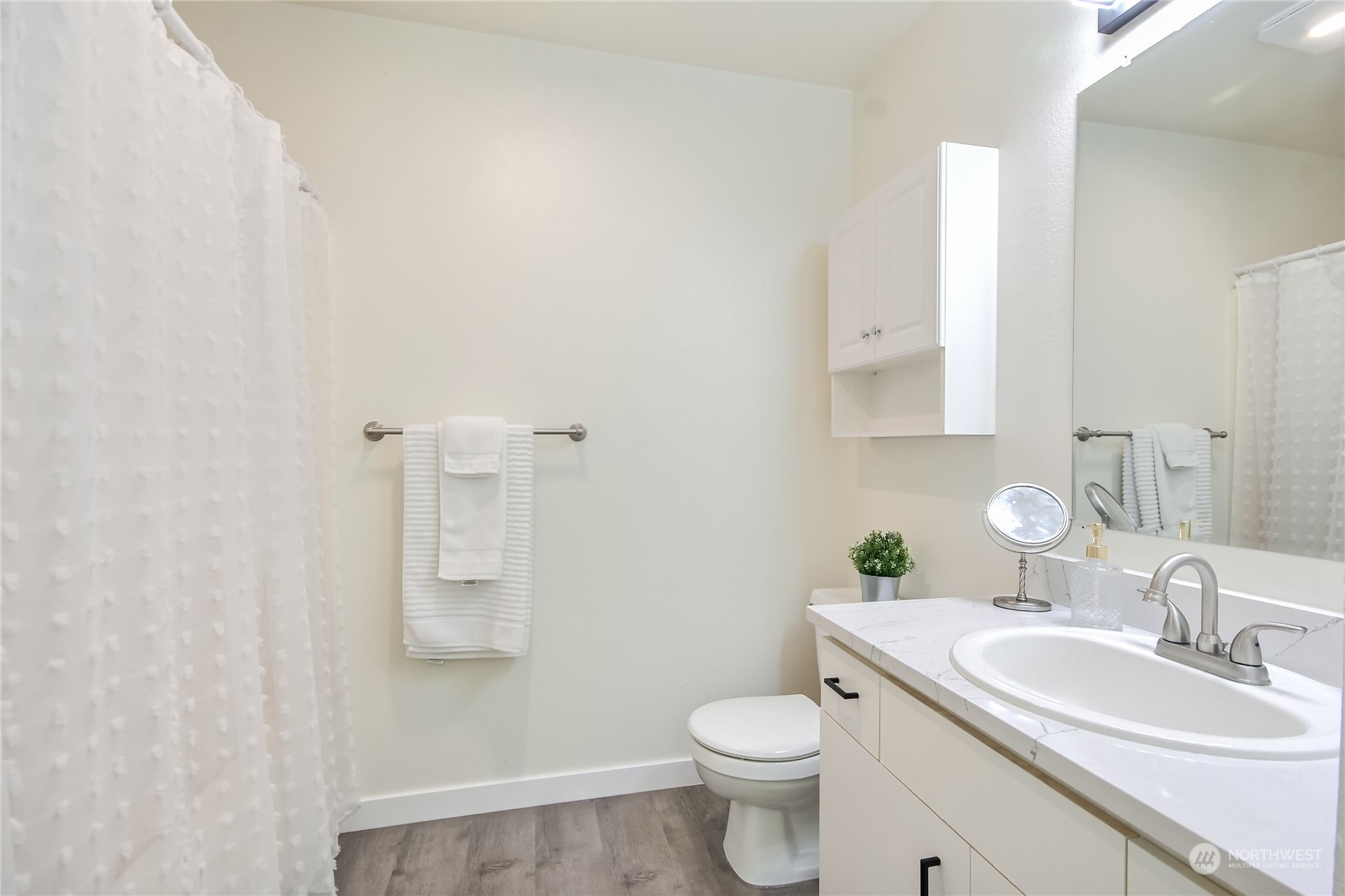 1825 South 330th Street, Unit E3 Federal Way, WA 98003 - Photo 15 of 26 a bathroom with a toilet a sink a mirror and vanity