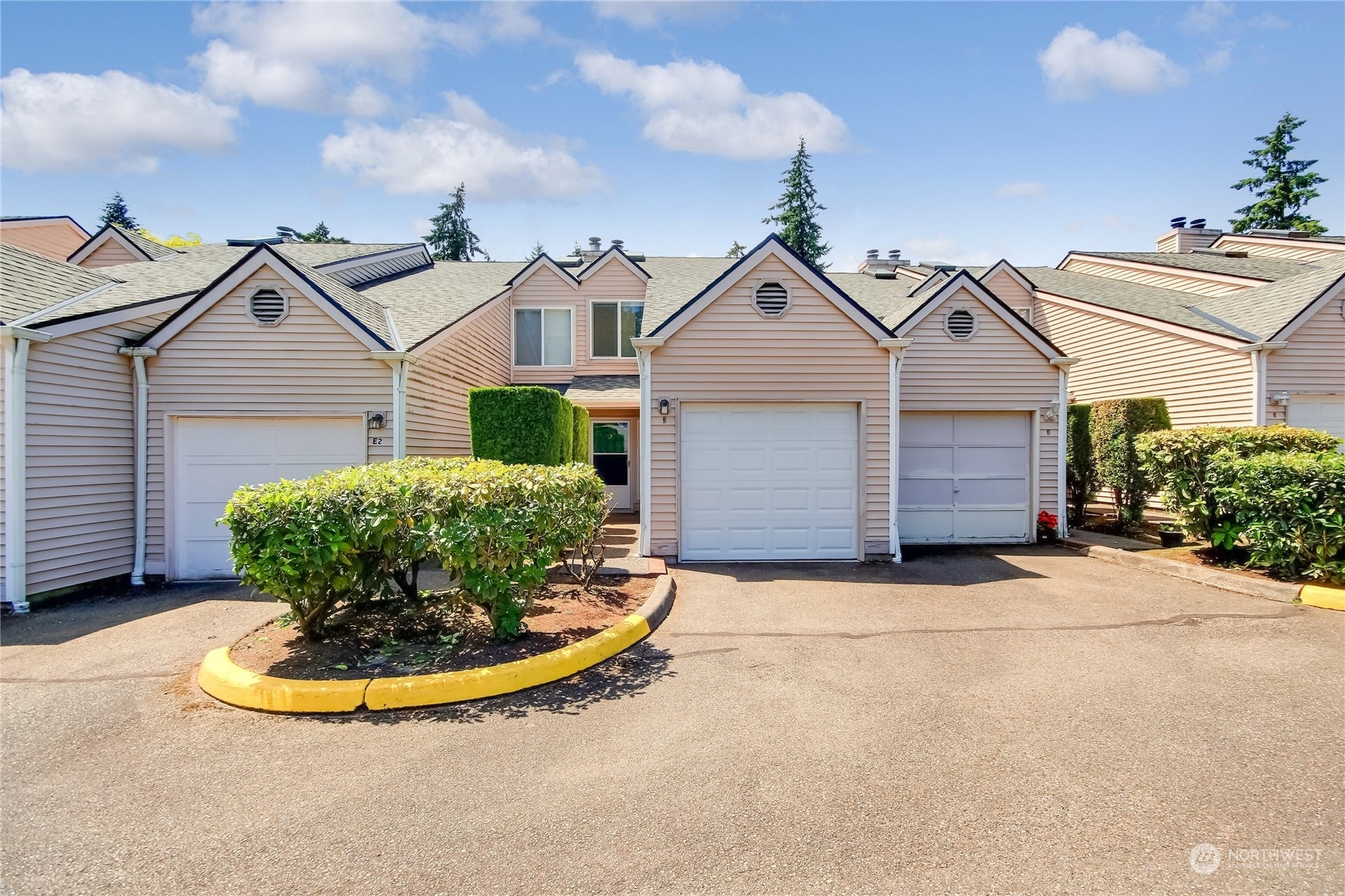1825 South 330th Street, Unit E3 Federal Way, WA 98003 - Photo 2 of 26 a view of a white house with a small yard and potted plants