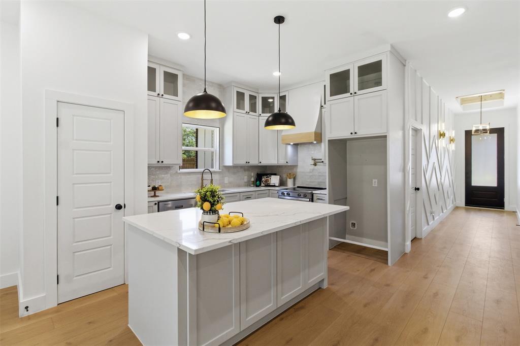 435 Waterboard Road Trinidad, TX 75163 - Photo 11 of 39 Kitchen featuring a central island with a light-toned countertop, white cabinetry with glass upper doors, stainless steel appliances, and wood-finish flooring