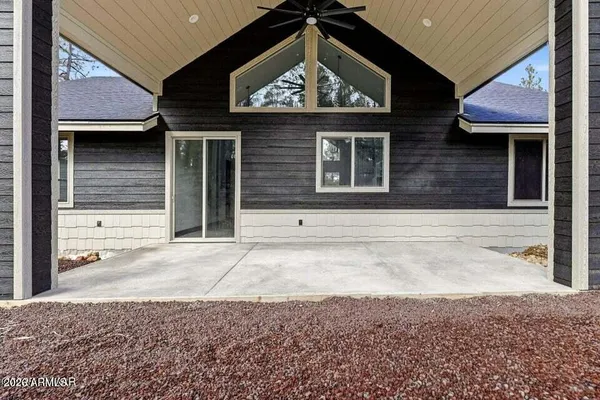 a view of a house with wooden fence next to a yard