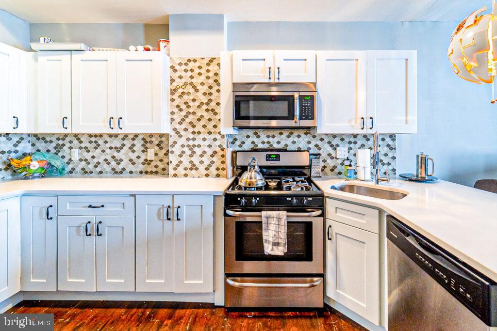 19 North 3rd Street Philadelphia, PA 19106 - Photo 6 of 14 a kitchen with granite countertop a stove a sink and a microwave