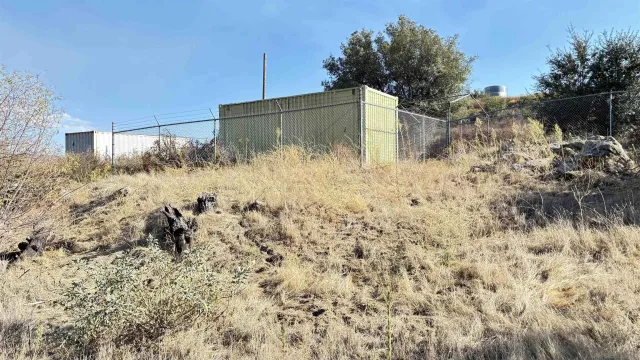 a view of a dry yard with mountains in the background