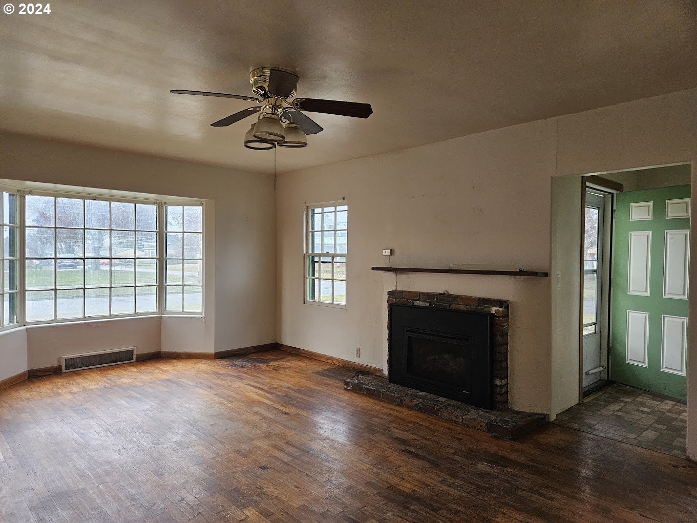 212 North Grant Street Goldendale, WA 98620 - Photo 5 of 15 an empty room with windows fireplace and a sink