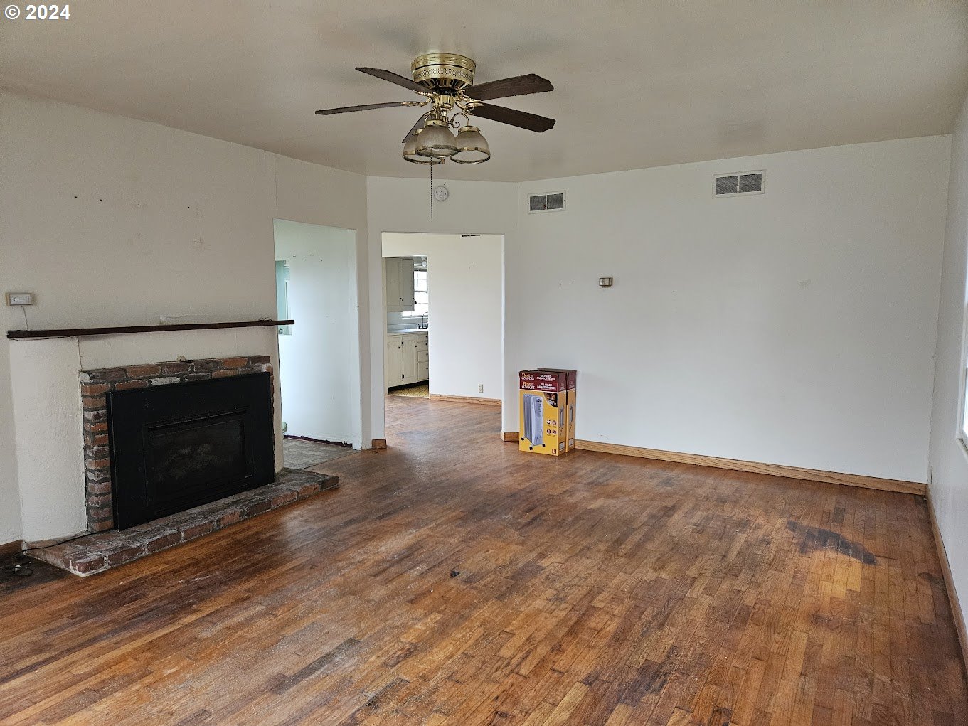 212 North Grant Street Goldendale, WA 98620 - Photo 6 of 15 a view of an empty room with a fireplace and a fan