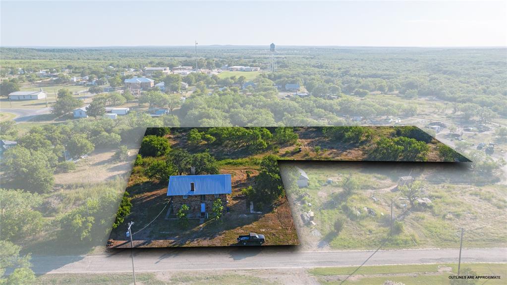 640 Ground Street Moran, TX 76464 - Photo 2 of 35 Aerial property overview featuring a single-story residence with a light blue metal roof and stone exterior