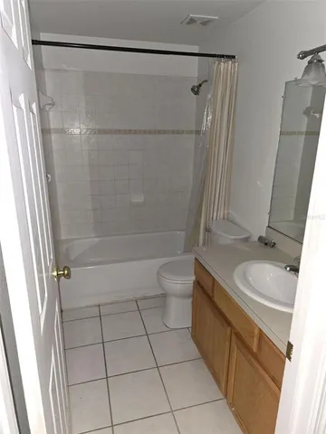 a bathroom with a granite countertop sink a toilet and shower
