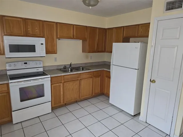 a kitchen with a sink a refrigerator and cabinets