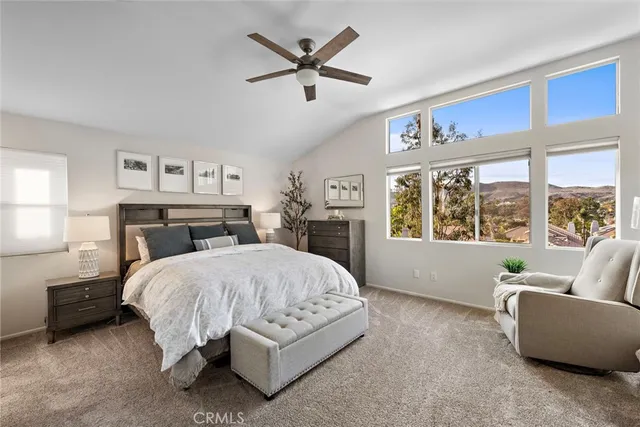 a spacious bedroom with a bed a couch and a flat screen tv