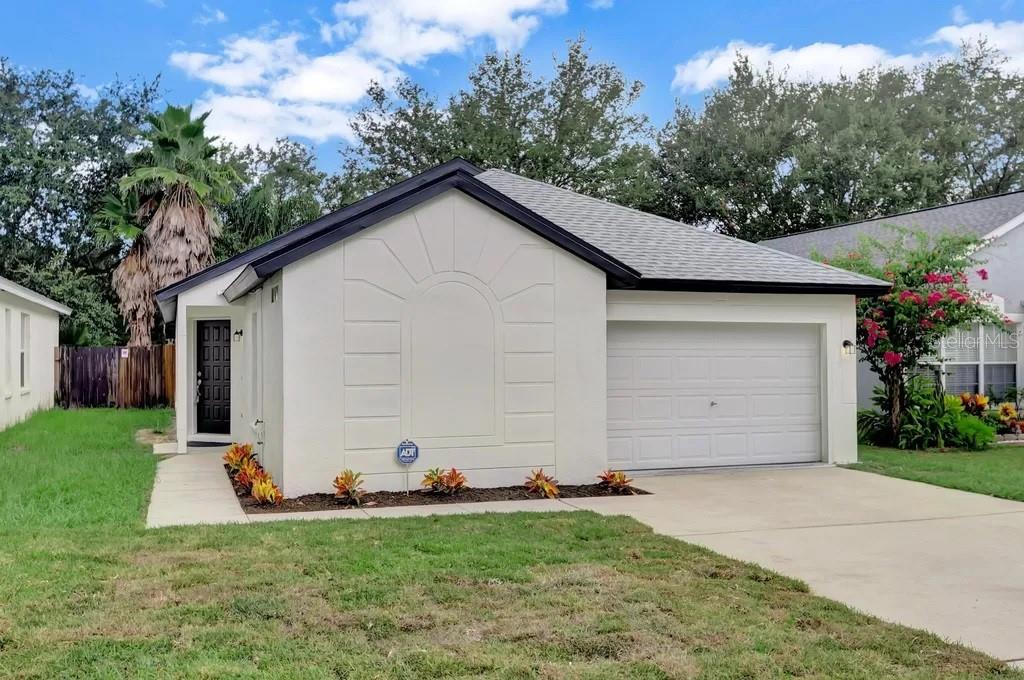 a view of a house with a yard and garage