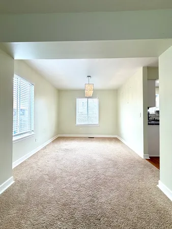 an empty room with windows and cabinet