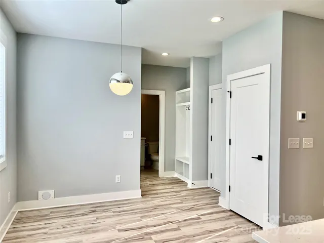 a view of a hallway with wooden floor and cabinet