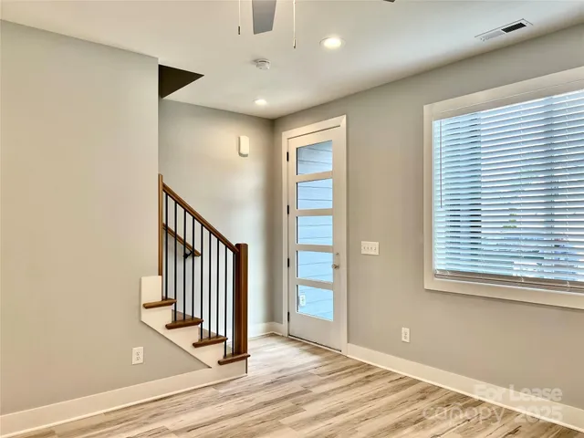 a view of a livingroom with wooden floor and stairs