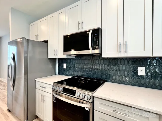 a kitchen with stainless steel appliances a stove microwave and sink