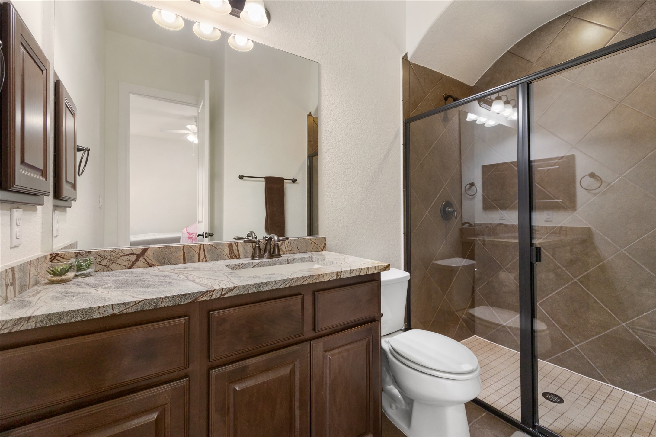 415 Bitterroot Lane Austin, TX 78737 - Photo 17 of 25 A well-appointed bathroom features an elegant granite vanity and a spacious, tiled shower.