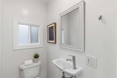 a bathroom with a sink a toilet and a mirror