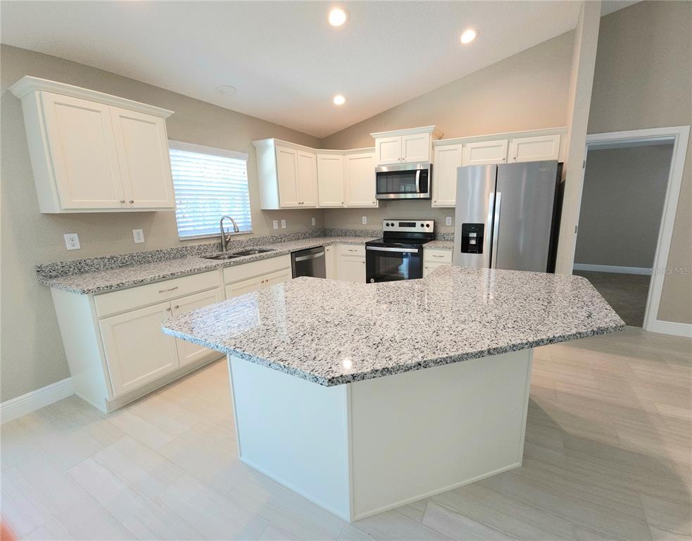 7794 North Keystone Drive Citrus Springs, FL 34433 - Photo 2 of 14 a kitchen with stainless steel appliances granite countertop a sink dishwasher stove top oven and refrigerator