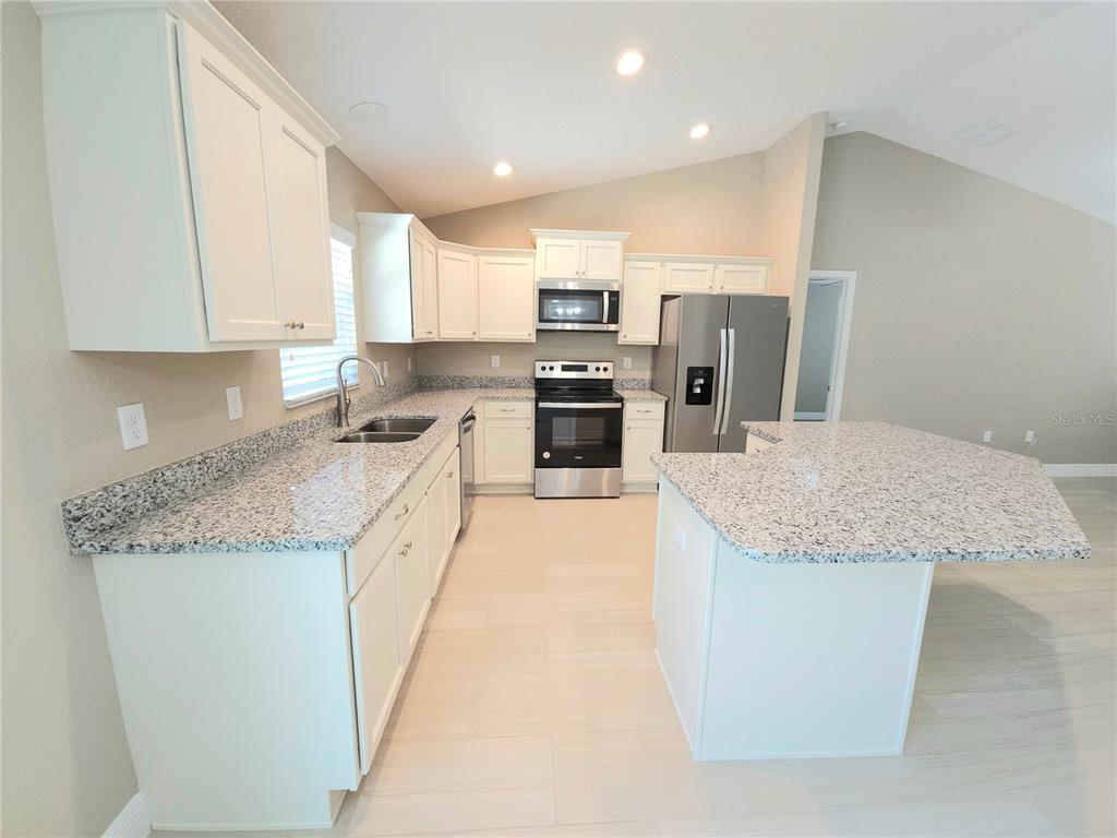 7794 North Keystone Drive Citrus Springs, FL 34433 - Photo 3 of 14 a large kitchen with granite countertop a large counter top stainless steel appliances and cabinets