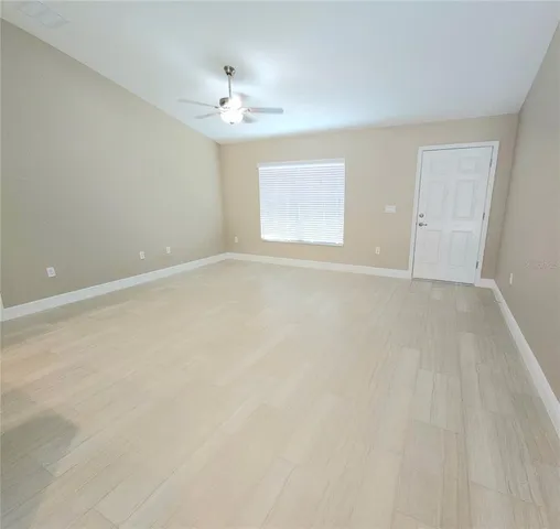 a view of an empty room with a chandelier fan