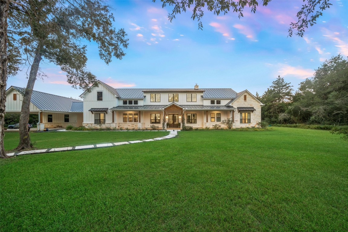 27201 Double Culvert Road Hempstead, TX 77445 - Photo 11 of 49 The home’s striking façade combines stone and board-and-batten siding beneath a standing seam metal roof. A welcoming front porch and manicured lawn complete the curb appeal.