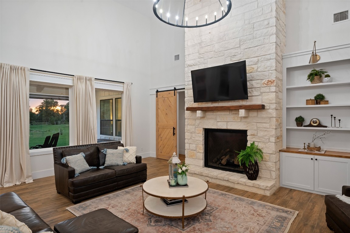27201 Double Culvert Road Hempstead, TX 77445 - Photo 12 of 49 Close-up of the living room fireplace reveals stone surround, rustic mantel, and built-in shelving for display or storage.