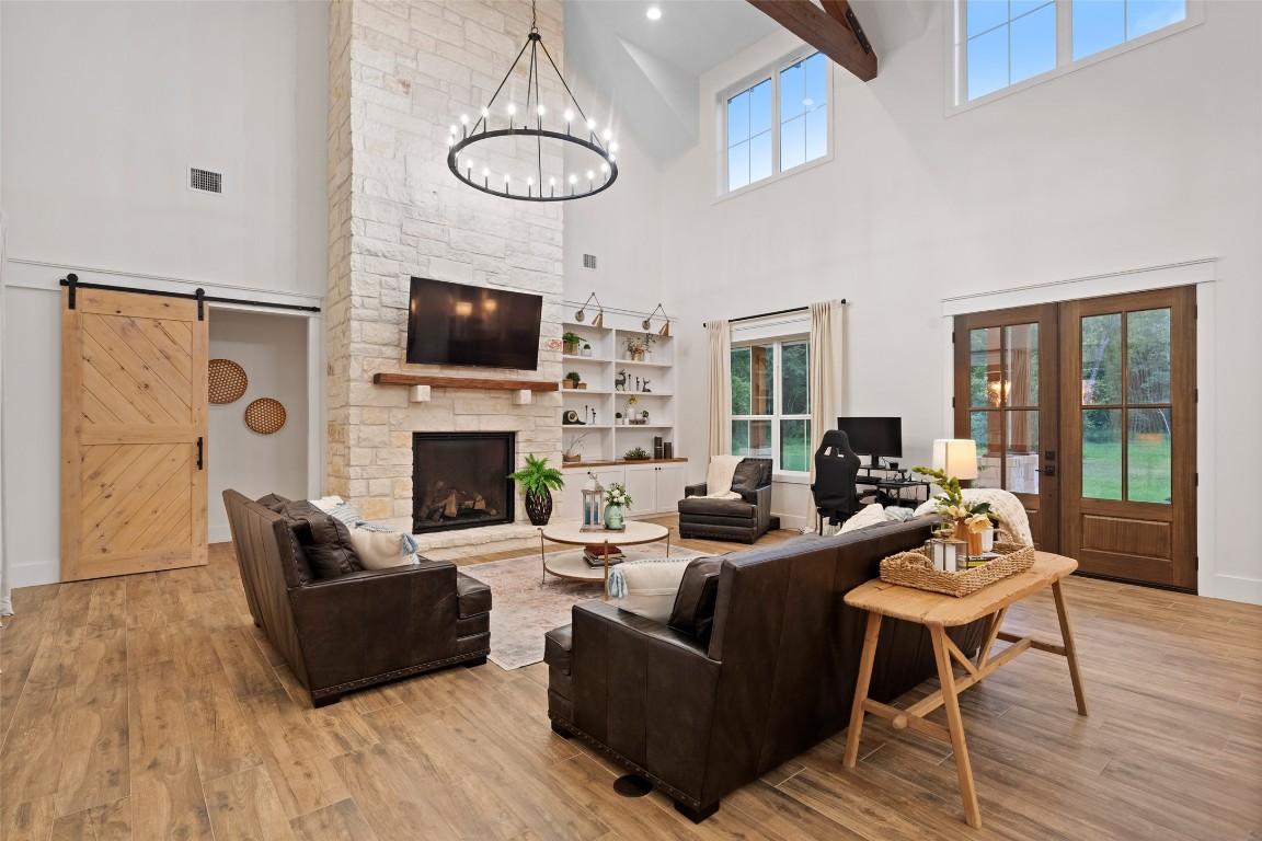 27201 Double Culvert Road Hempstead, TX 77445 - Photo 13 of 49 The main living room boasts a soaring stone fireplace, wood beams, and wide-plank tile floors, creating a dramatic yet comfortable focal point.