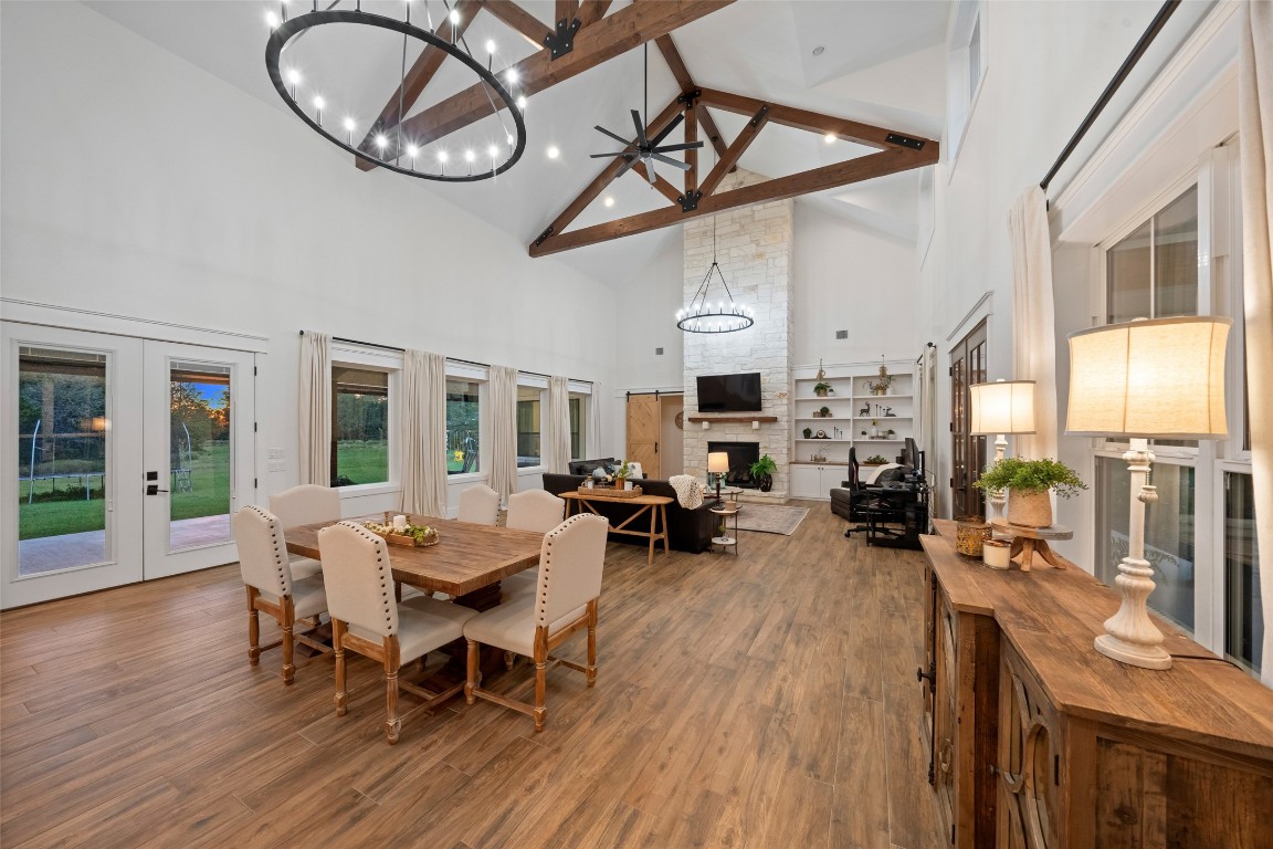 27201 Double Culvert Road Hempstead, TX 77445 - Photo 15 of 49 Wide view of the open-concept dining and living areas, highlighting dramatic vaulted ceilings with exposed trusses.