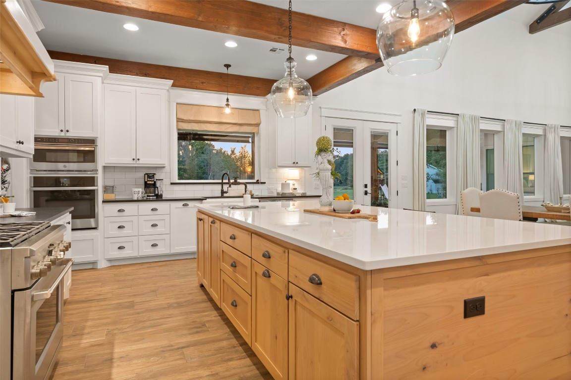 27201 Double Culvert Road Hempstead, TX 77445 - Photo 21 of 49 Angle from the Café cooktop toward the island showcases the double ovens, leathered granite counters, and crisp white cabinetry.
