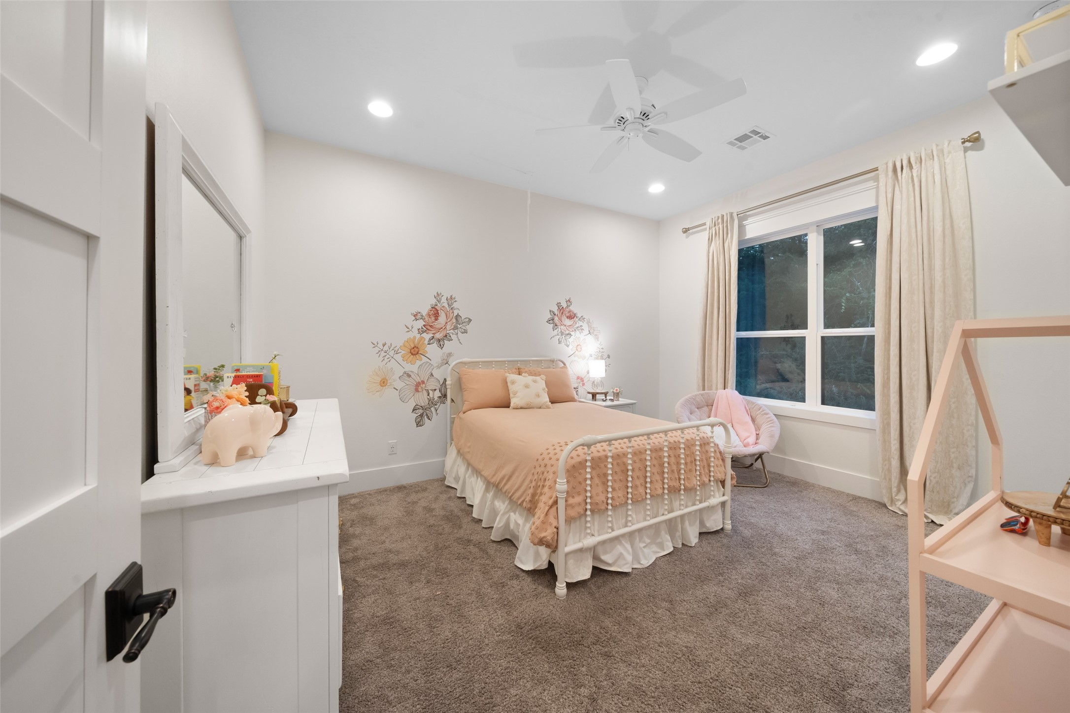 27201 Double Culvert Road Hempstead, TX 77445 - Photo 38 of 49 Secondary bedroom with floral wall accents, cozy seating nook, and ample floor space for versatile furniture layouts.