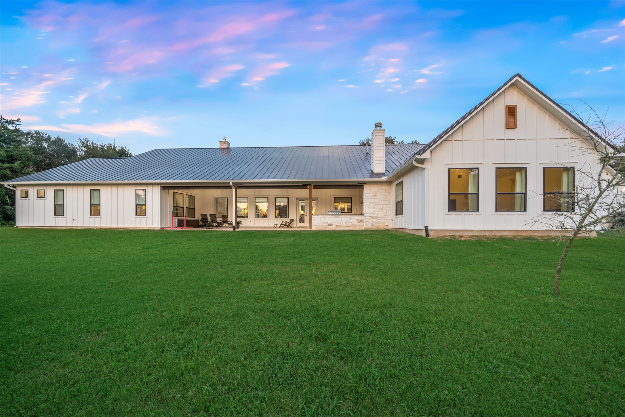 27201 Double Culvert Road Hempstead, TX 77445 - Photo 39 of 49 Expansive backyard elevation highlights the home’s full-length covered porch with wood ceiling and seamless indoor-outdoor flow.