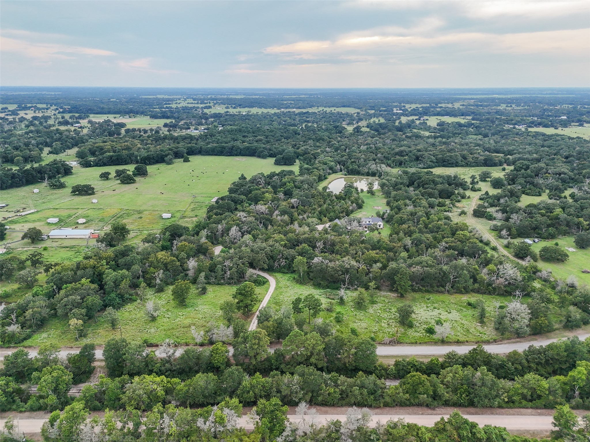 27201 Double Culvert Road Hempstead, TX 77445 - Photo 43 of 49 Aerial shot reveals the full scale of the property with rolling pastures, mature trees, and private drive access.