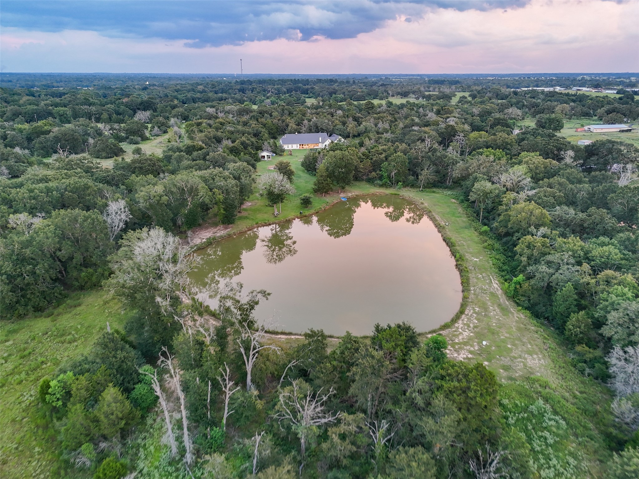 27201 Double Culvert Road Hempstead, TX 77445 - Photo 46 of 49 Aerial angle shows the pond’s proximity to the home, framed by wooded privacy and open pasture.