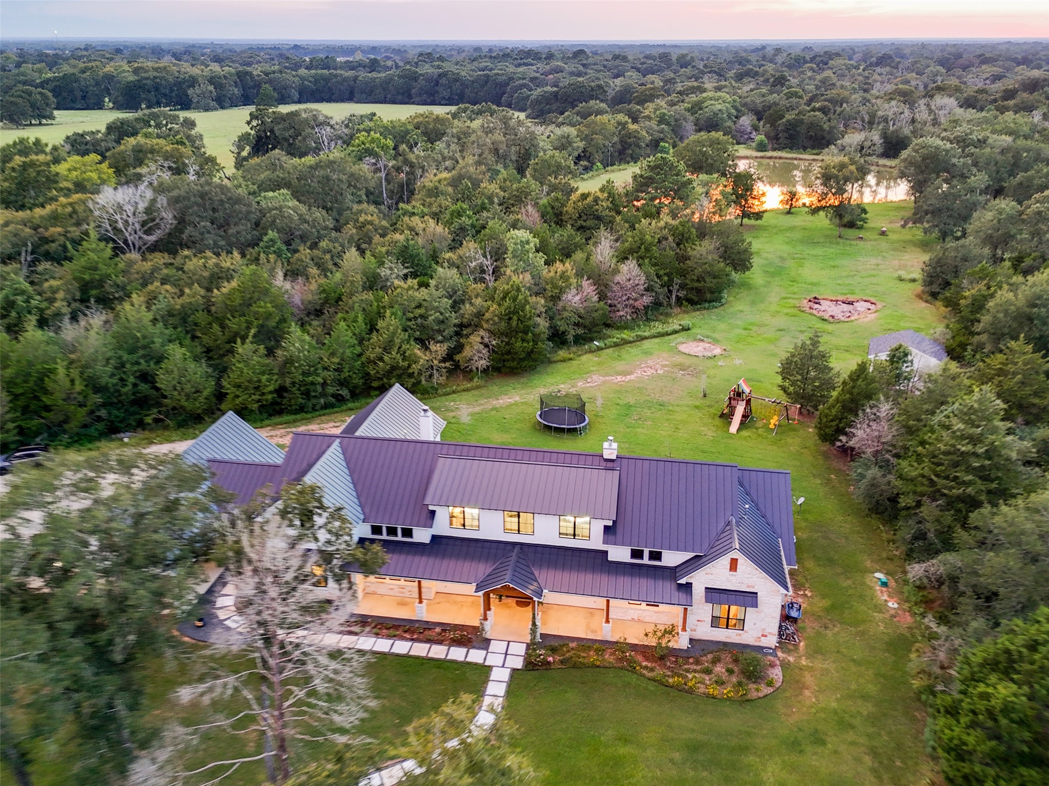 27201 Double Culvert Road Hempstead, TX 77445 - Photo 47 of 49 Overhead perspective of the residence emphasizes the landscaped entry, metal roof, and spacious yard extending toward the pond.
