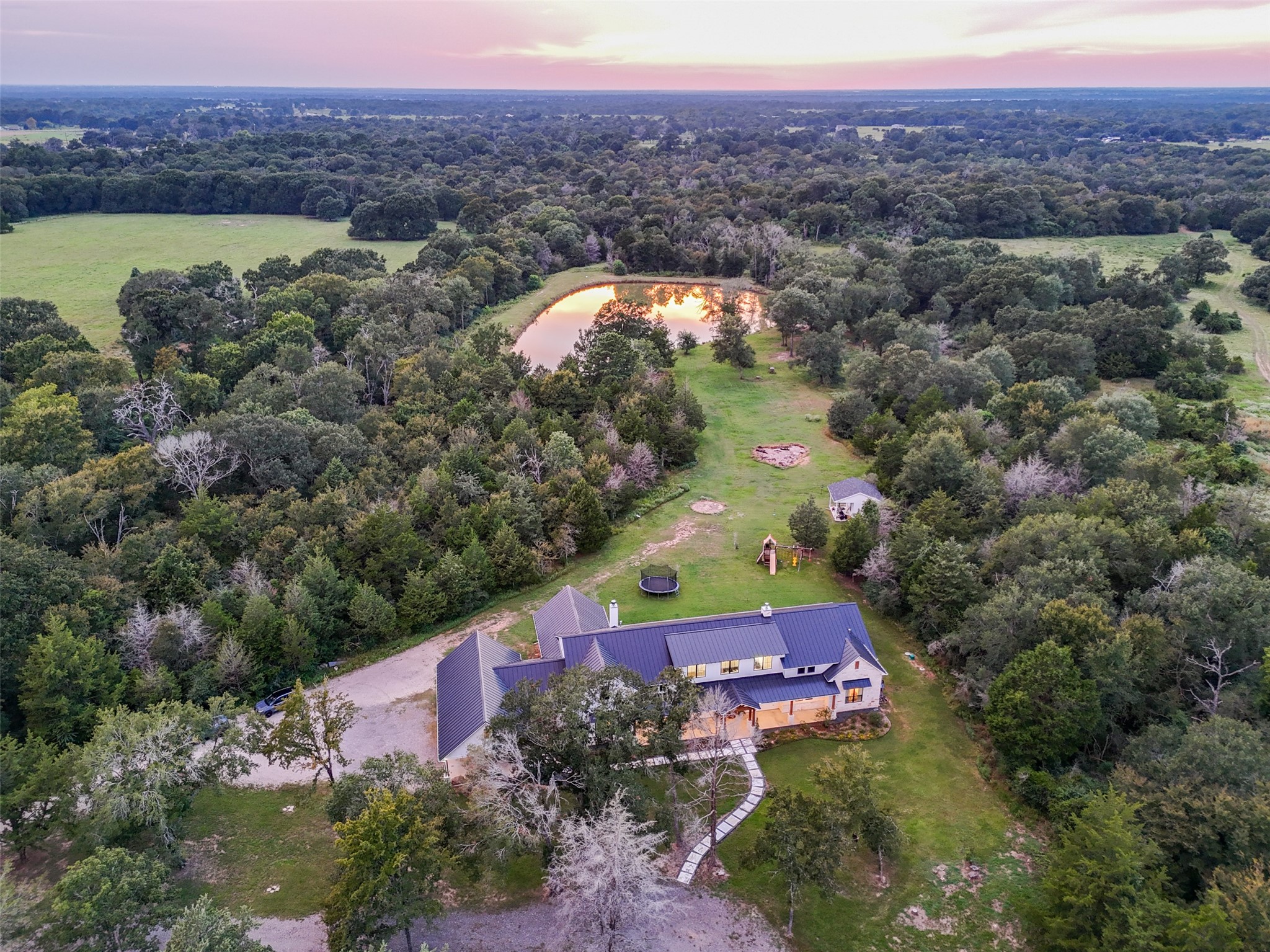 27201 Double Culvert Road Hempstead, TX 77445 - Photo 48 of 49 Wide aerial view showcases the home’s private placement among trees with sweeping acreage stretching in all directions.