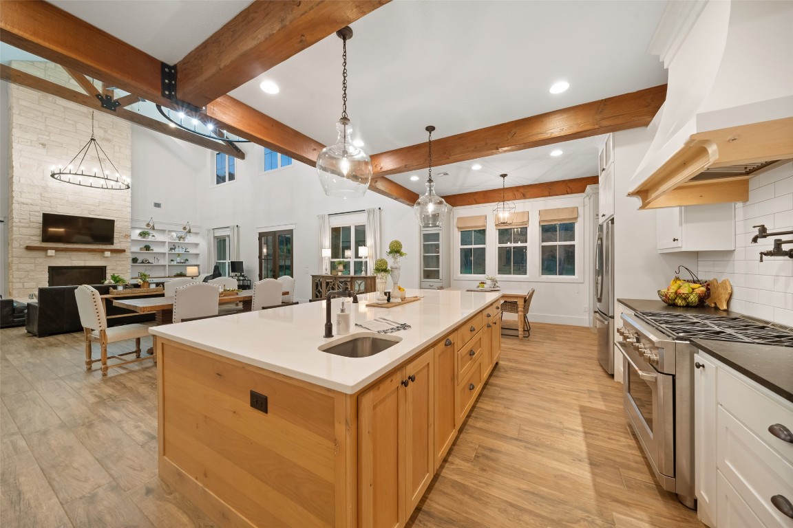 27201 Double Culvert Road Hempstead, TX 77445 - Photo 6 of 49 The chef’s kitchen impresses with a six-burner Café gas cooktop, quartz island with veggie prep sink, and under-cabinet lighting. Exposed wood beams and open shelving add farmhouse charm.
