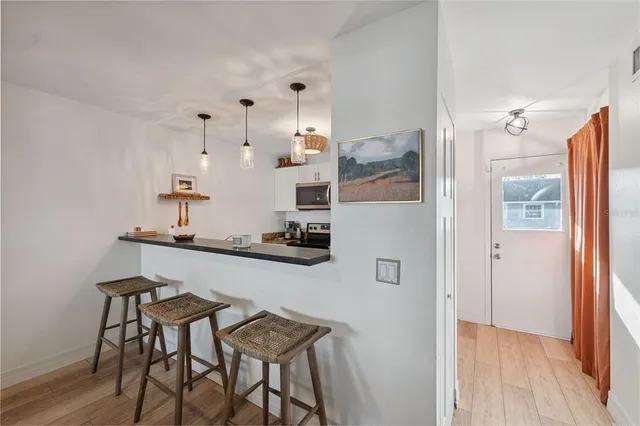 a kitchen with stainless steel appliances a table and chairs in it