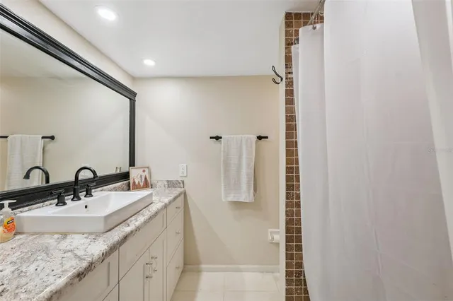a bathroom with a granite countertop sink and a mirror