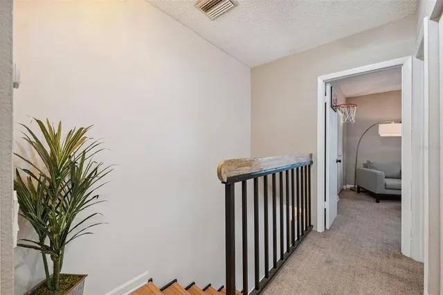 a view of a hallway with a flower pot and a table in front of it